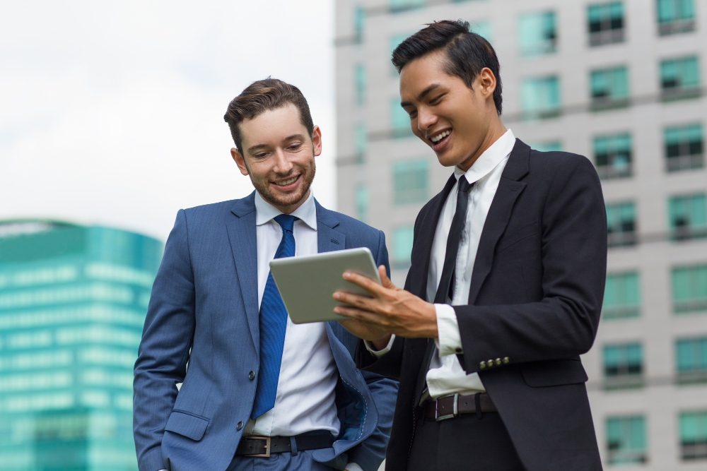 closeup smiling coworkers using tablet outdoors