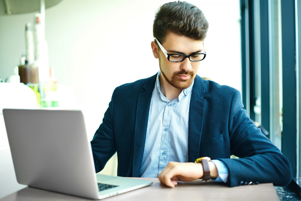 young fashion smiling hipster man city cafe during lunch time with notebook suit looking watches