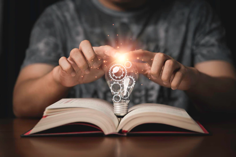 student hands touching lightbulb which have mechanical gear inside open book creative thinking problem solving education knowledge concept 50039 4115