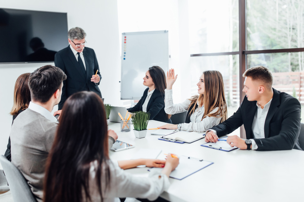 boss businessman holding papers hands smiling young team coworkers making great business discussion modern coworking office