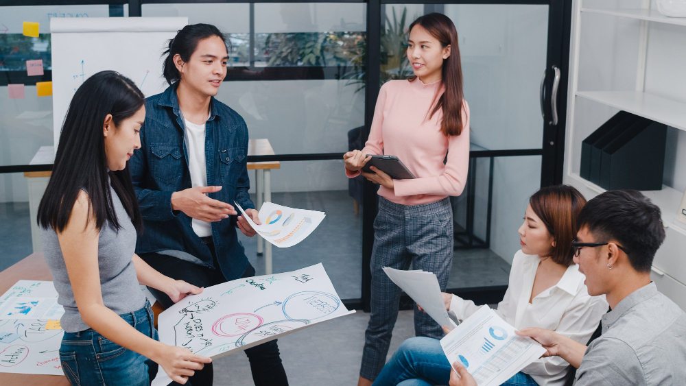 happy young asian businessmen businesswomen meeting brainstorming ideas