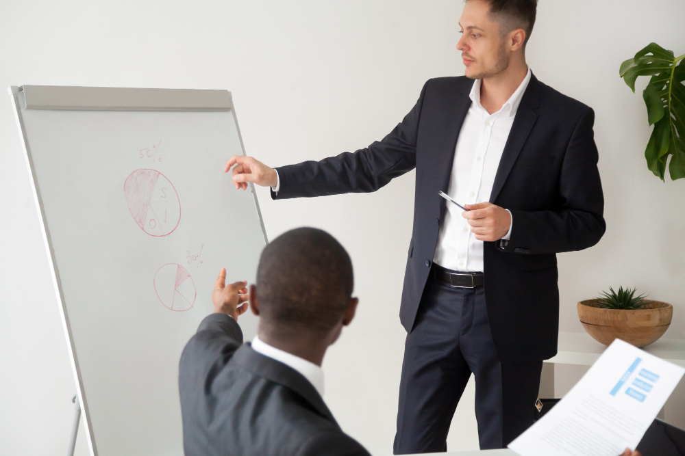 multiracial business partners brainstorming analyzing project statistics with flip chart