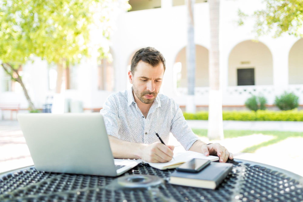 self employed man with laptop books preparing schedule table garden