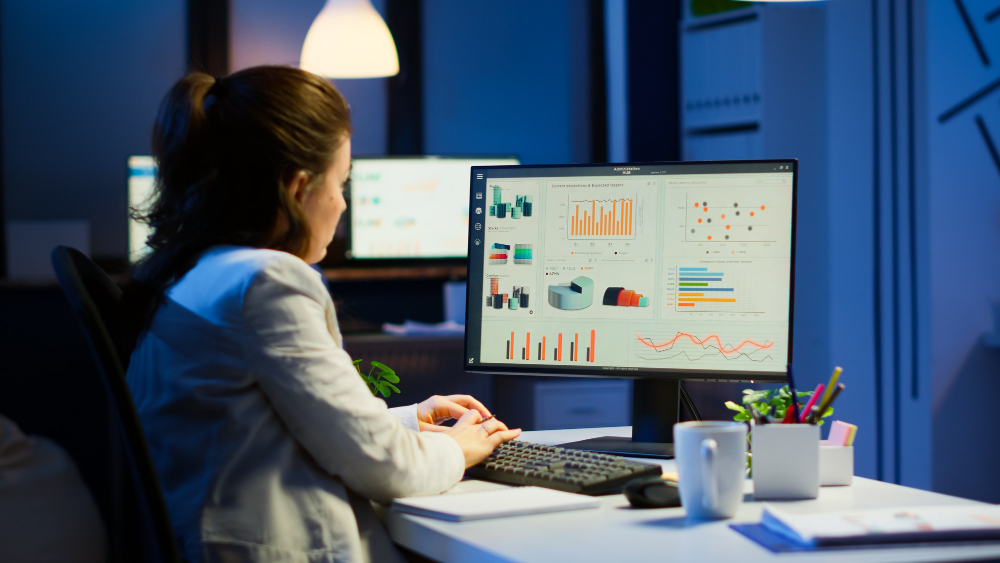 busy woman working night front computer taking notes writing notebook annual reports checking financial project focused employee using technology network wireless doing overtime job