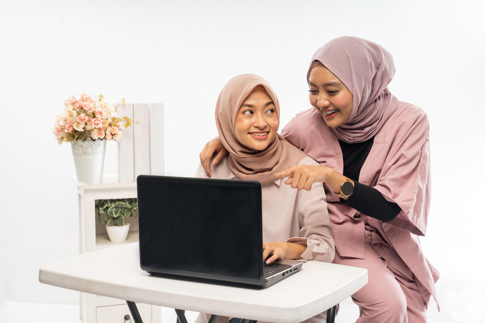 female muslim with hijab working their laptop together