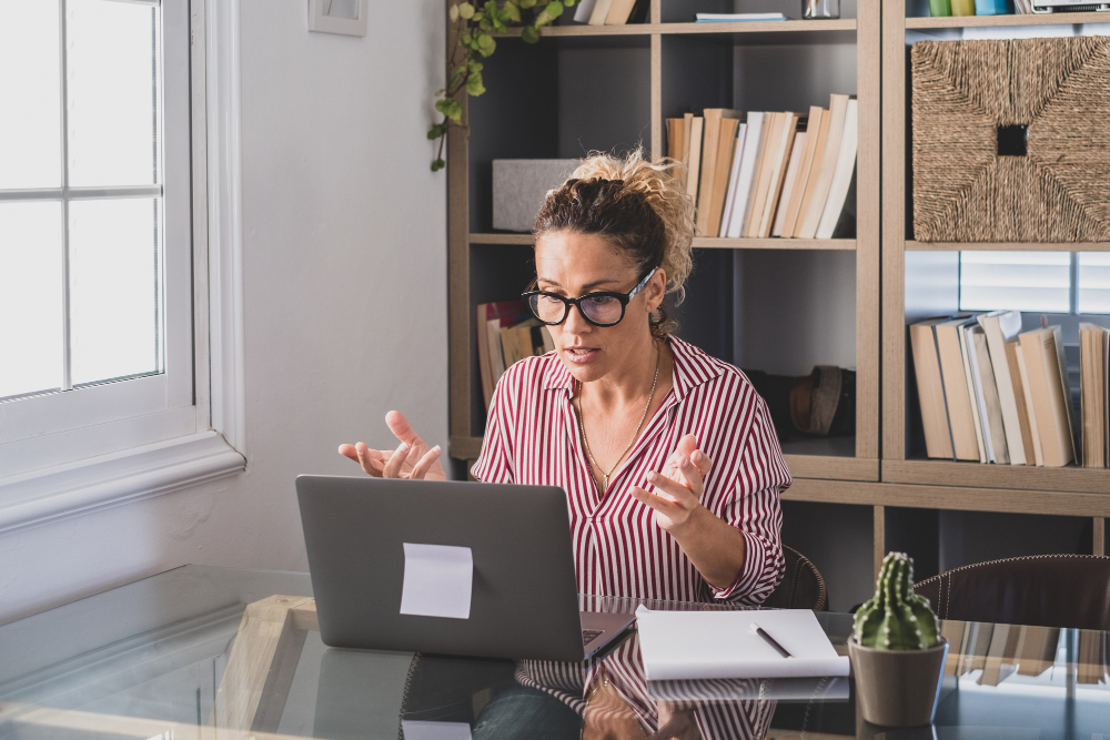 one young woman working home office with laptop notebook taking notes talking video conference one businesswoman calling communicating